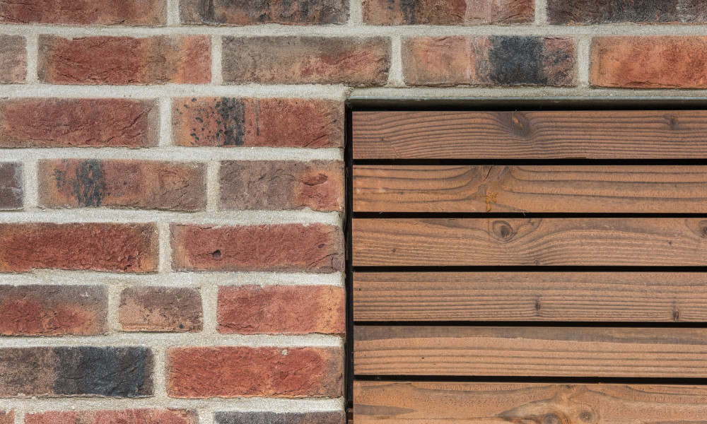 Rot-bunte Fassade mit Holz-Element | Klinkerwerke Muhr